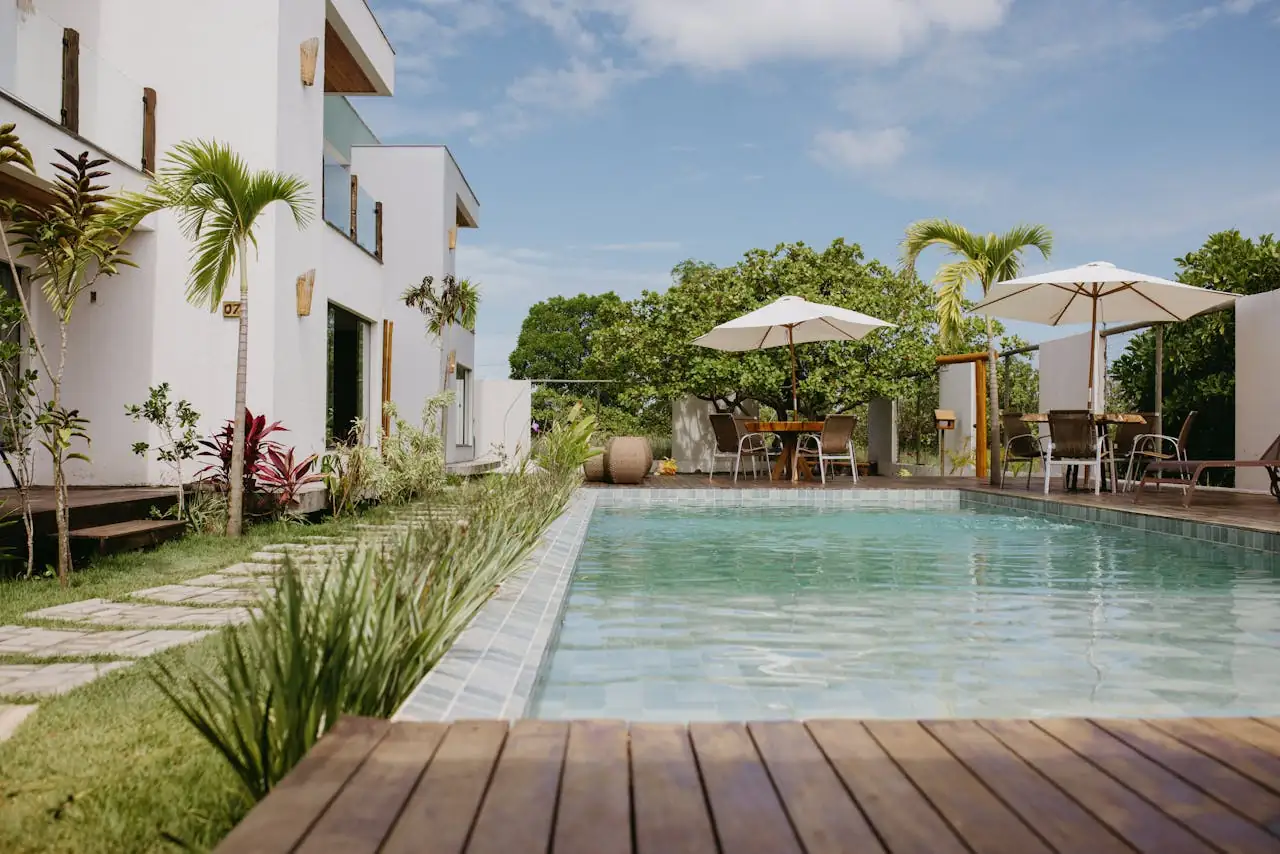 Propriétaires à Nice 3 raisons de déléguer votre Airbnb en 2026 Beautiful modern villa with a pool surrounded by lush greenery in Bahia, Brazil.