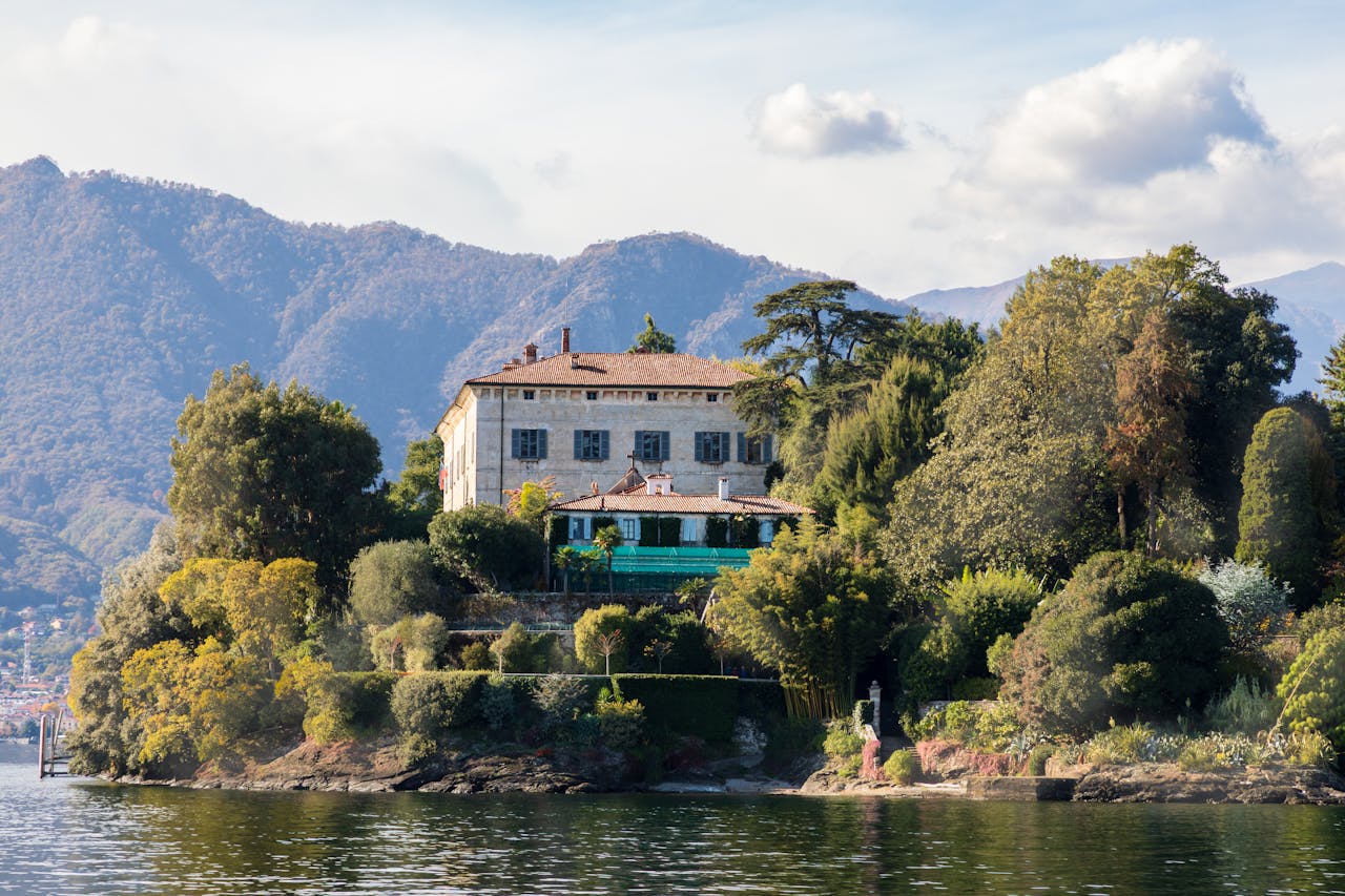 who-we-are Picturesque villa on the shores of Lake Como surrounded by lush greenery and mountain views.